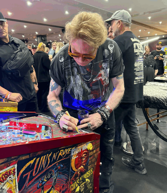 Guns N’ Roses frontman Axl Rose signs the Jersey Jack Pinball machine that was auctioned off.